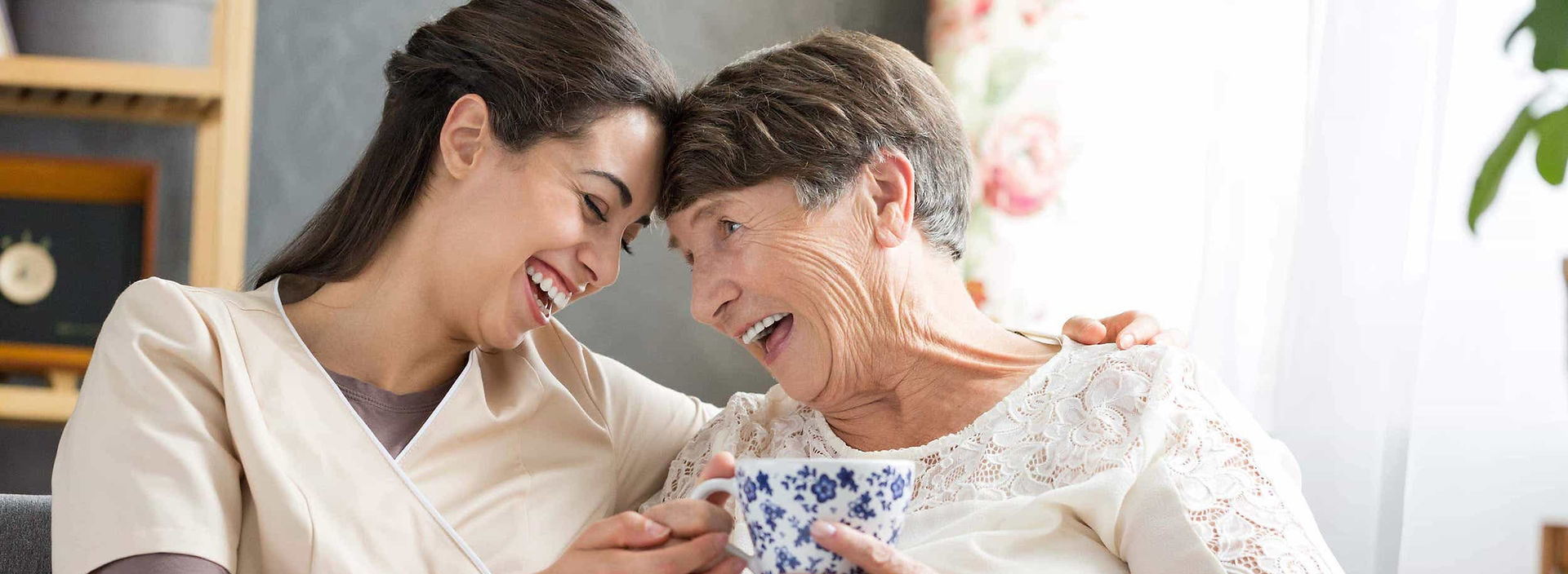 Seniorin wird liebevoll von einer 24-Stunden-Pflegekraft zu Hause betreut